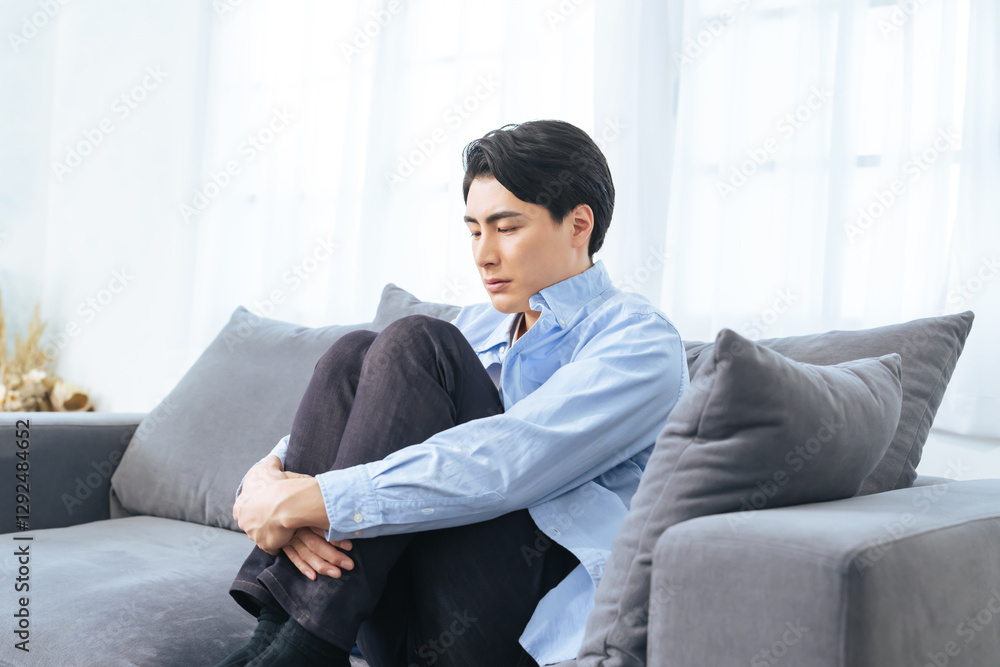 Fototapete 落ち込む、孤独、がっかり、失敗、呆然、引きこもり、男性、寂しい、憂鬱、うつ病、考える、悩む、悩み、困る、疑問、心配、不安、不満、トラブル、問題、憂うつ、ストレス、ノイローゼ、メンタルヘルス、残念、緊張、プレッシャー、疲労、過労、後悔、悔しい、ソファー、座る、インテリア、室内、部屋、ネガティブ、しょんぼり、挫折、若い、暗い、日本人、ライフスタイル、カジュアル、リビングルーム、仮病、コピースペース、イ