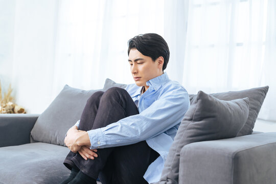 落ち込む、孤独、がっかり、失敗、呆然、引きこもり、男性、寂しい、憂鬱、うつ病、考える、悩む、悩み、困る、疑問、心配、不安、不満、トラブル、問題、憂うつ、ストレス、ノイローゼ、メンタルヘルス、残念、緊張、プレッシャー、疲労、過労、後悔、悔しい、ソファー、座る、インテリア、室内、部屋、ネガティブ、しょんぼり、挫折、若い、暗い、日本人、ライフスタイル、カジュアル、リビングルーム、仮病、コピースペース、イ