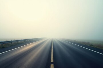 Fototapeta premium A misty road disappearing into the fog, a journey of uncertainty and potential
