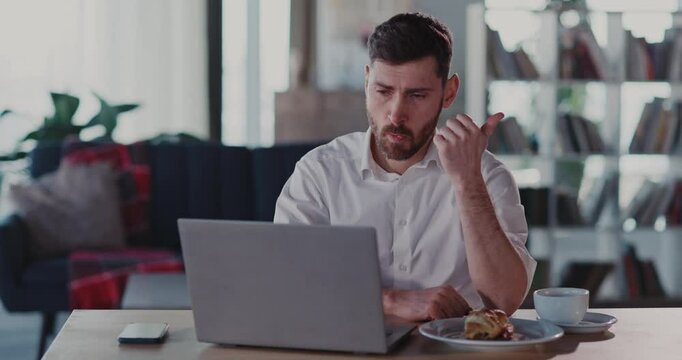 Caucasian funny comical bearded man using laptop wtahcing lifehack fun internet video counting tips on his left hand fingers Entertainment home.