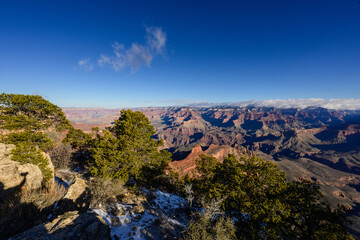 Fototapeta premium Grand Canyon with clear skies sunshine, blue sky and some snow on ground