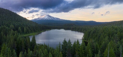 Majestic Mount Hood at dawn, reflected in a tranquil alpine Trillium Lake, surrounded by dark forest. Peaceful mountain scenery.  Oregon, United States