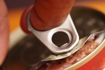 Opening a can of tuna with a metal lid in a home kitchen