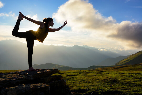 Silhouette of a woman doing standing bow pulling pose in mountains, Col d'Aubisque, Pyrenees, France
