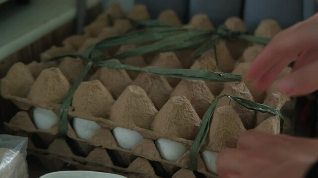 Hands Using Scissors In Cutting Plastic Straw Tied On Trays of Eggs In House. closeup shot