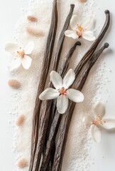 Fototapeta premium Elegant Arrangement of Vanilla Beans, White Flowers, and Sugar Crystals on a Bright Surface for Culinary and Aromatic Inspiration