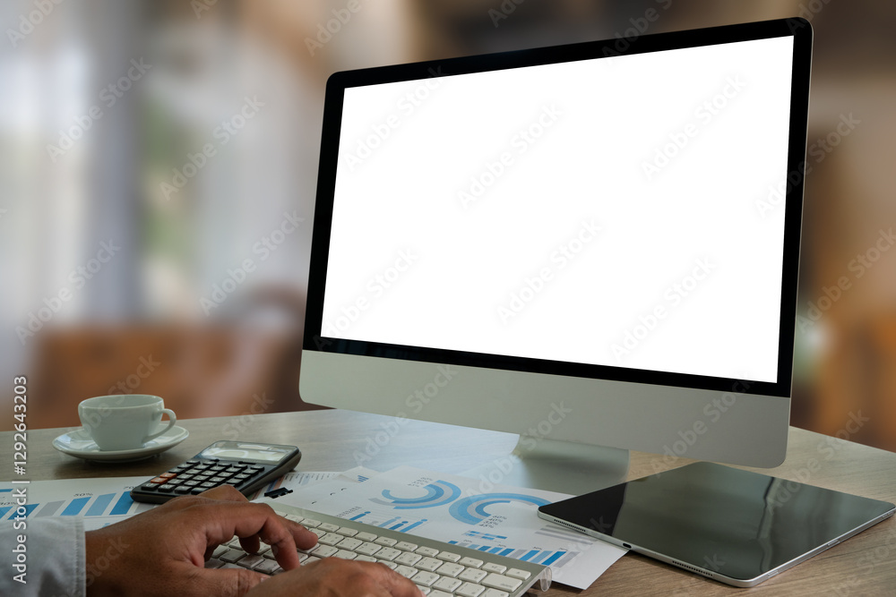 Poster a businessman is using a modern laptop on a white desk in a bright office, typing on a keyboard whil