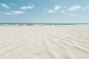 wide camera angle captures deserted sand beach with gentle waves under clear blue sky, evoking tranquility and solitude