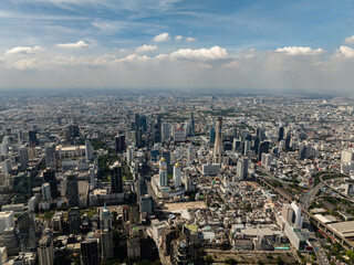 Prominent skyscrapers and urban sprawl make up the bustling Bangkok cityscape under clear skies....