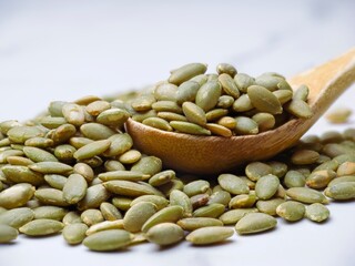   Roasted pumpkin seeds on a wooden spoon.