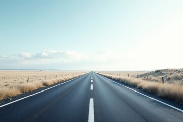 Fototapeta premium Endless Asphalt Journey A Long Straight Road Through Arid Plains Under a Pale Sky