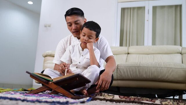 Muslim Father Teaching His Son to Read the Quran at Home