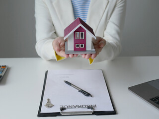 Real estate investment agent. Agent's hand holding a house to deliver a house to clients, home...