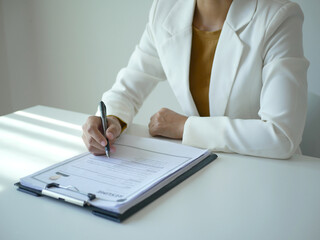 Young businesswoman holds a resume and evaluates it. Views the personal history of job applicants....