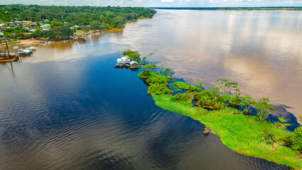 Aerial View of the Amazon River in Colombia, Showcasing Lush Greenery and Nearby Settlement