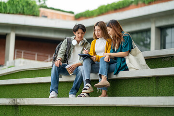 Students at university with fun for learning,Walking,laughing and bonding and talking.asian group of gen z friends student giving high five outdoor with books ready for education at college campus.