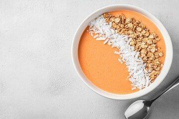Vibrant Orange Smoothie Bowl With Granola And Coconut topping