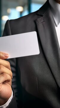 Professional Businessman Holding Blank Card in Modern Office Setting