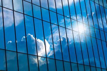 Blue glass reflection of modern building with clear sky background with clouds. Environment concept.