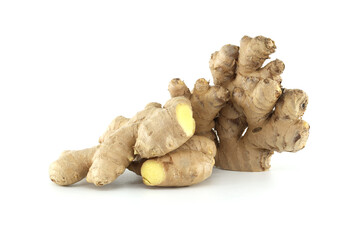 Fresh ginger root with a visible yellow inside lying on a white background