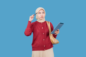 A woman in a red sweater is holding a pen and looking at a tablet. She is deep in thought, possibly...