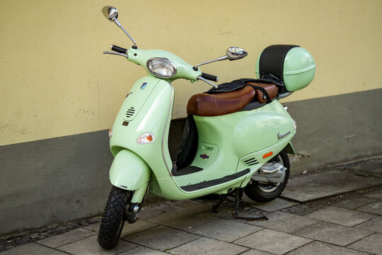 A mint Vespa scooter with top case. The Vespa is a motor scooter from the Italian company Piaggio. It is one of the best-known and most popular scooter typ