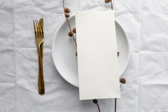 A minimal 5x7 inch blank menu paper placed on a ceramic plate, styled for elegant wedding table settings or fine dining menu mockups.