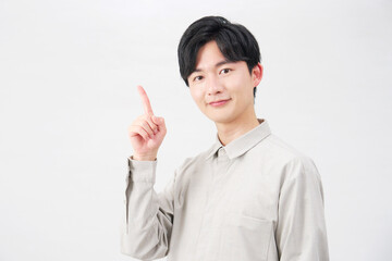 左側を指差す男性　20代　白背景