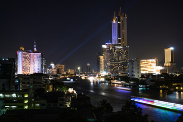 View of Bangkok, Thailand at night, showing the Chao Phraya River and boats. Taken on 22 Dec 2023.