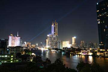 View of Bangkok, Thailand at night, showing the Chao Phraya River and boats. Taken on 22 Dec 2023.