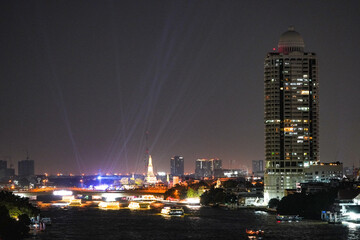 View of Bangkok, Thailand at night, showing the Chao Phraya River and boats. Taken on 22 Dec 2023.
