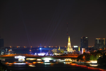 View of Bangkok, Thailand at night, showing the Chao Phraya River and boats. Taken on 22 Dec 2023.