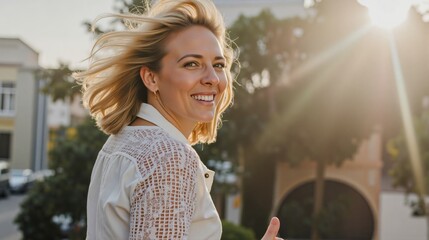 Smiling blonde woman in white lace blouse stands outdoors with sun rays illuminating her during golden hour The warm sunlight creates glowing and serene atmosphere highlighting her joyful expression