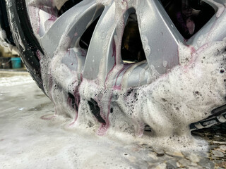 Car wheel cleaning process. Rim cleaner gives purple chemical reaction when removing metal or iron...