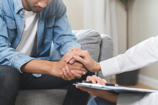 Psychology, depression. Sad asian young man consulting with psychiatrist while patient counseling mental therapy problem with doctor at clinic. Psychologist encouraging with sick mental health person.