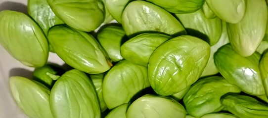 Macro shot of fresh, glossy green petai beans, also known as stink beans, commonly used in Southeast Asian cuisine.