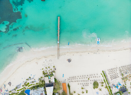 A beach with a pier and a boat in the water