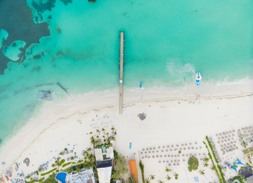 A beach with a pier and a boat in the water