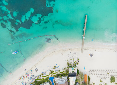A beach with a pier and a hotel in the background