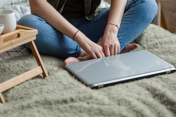 A young freelance woman who has a video call with a colleague working online from home in a cozy atmosphere on the bed. The concept of remote work from home. I work remotely, blogger.