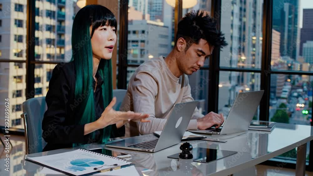 Poster two professionals work on laptops in a modern office. the video captures a side angle, highlighting 