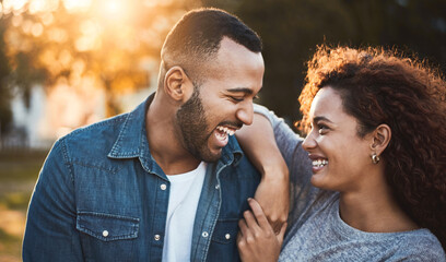 Fototapeta premium Happy, sunshine and couple in park laugh together for bonding, relationship and conversation outdoors. Dating, lens flare and man with woman in nature for talking, romance and relax on weekend