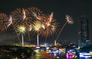 View of Bangkok, Thailand at night, with the Chao Phraya River, beautiful fireworks and boats....