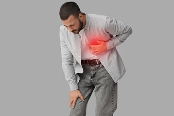 Young man having heart attack on grey background