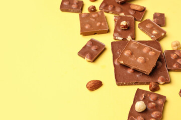 Sweet tasty chocolate with nuts on  yellow background