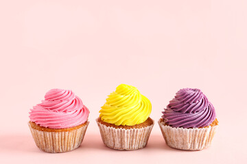 Tasty colorful cupcakes on pink background