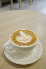 Milk coffee with latte art, Hot coffee on wooden table