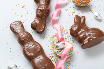Chocolate Easter eggs with sprinkles and bunnies on blue background
