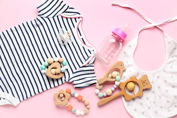 Composition with baby clothes and accessories on pink background