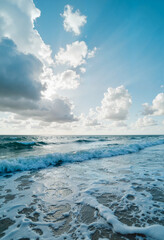 Obraz premium Tranquil ocean waves caressing the shoreline under a cloudy sky, peace
